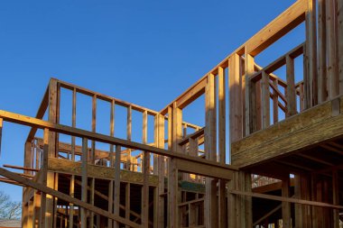 İnşa kiriş ev inşaat ve ahşap truss ile mavi gökyüzü altında yakın çekim sonrası ve çerçeve ışınlayın. Ahşap çerçeve ev, gayrimenkul arka plan