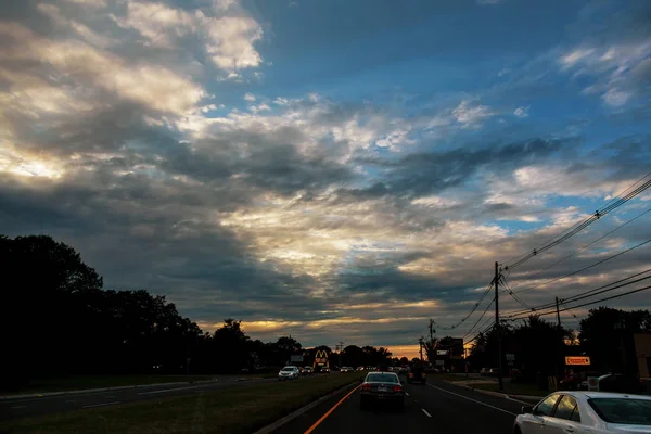 Auto nel traffico al semaforo in una serata di tramonto autostrada occupato — Foto Stock