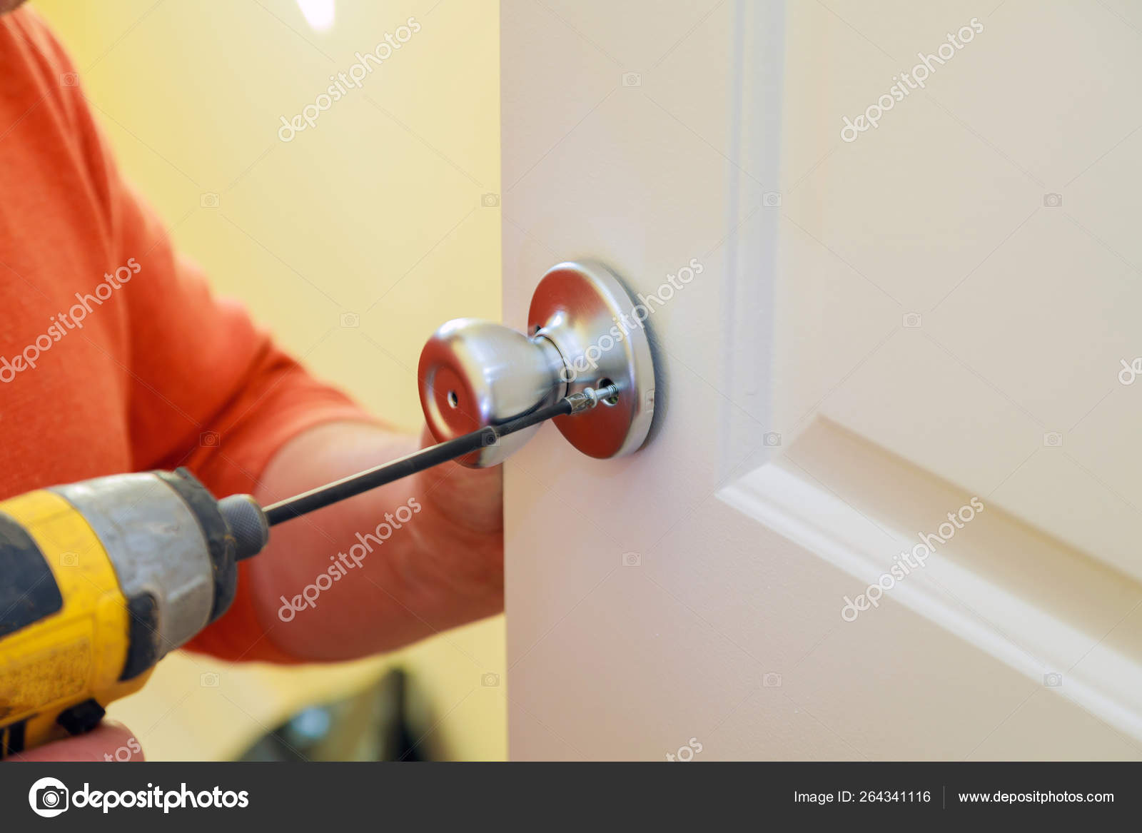 Man Repairing The Doorknob Closeup Of Worker S Hands Installing