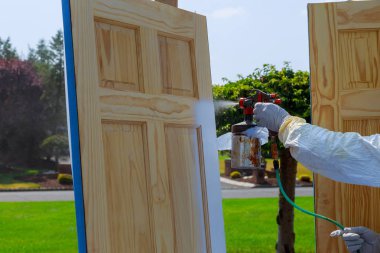 Boya boyama Master boyama ahşap kapılar ile sprey tabanca yakın çekim.