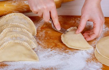 Kadın mutfakta çatalla peroji yapıyor.