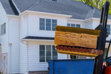 Forklift yükleme yapı malzemeleri. Stokta tahtalar ahşap çerçeve ve kiriş inşaat lojistiği yığını.