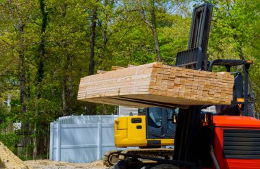 Çatal kaldırıcı şantiyede inşaat malzemesi kiriş çerçevesini taşımak