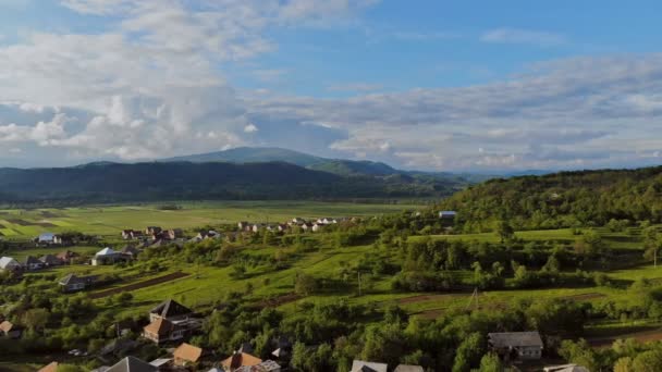 Solig sommardag och liten by i Montain i en blå himmel — Stockvideo