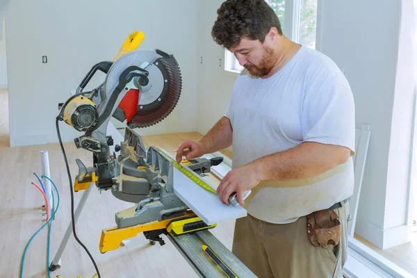 Trabajador de contratista de construcción utilizando la medición y marcado de una antes de cortar tablero de madera — Foto de Stock