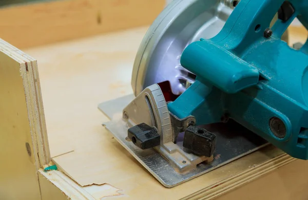 Carpenter using circular electro saw cutting kitchen furniture, — Stock Photo, Image