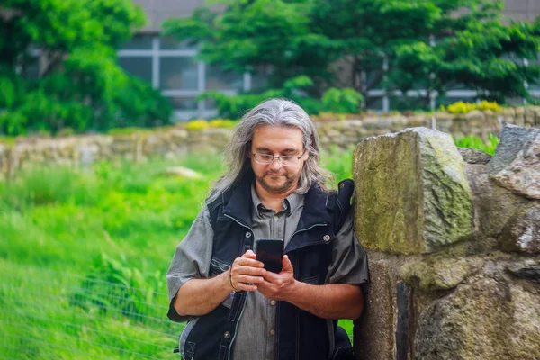 Man calling with mobile phone is calling by mobile telephone on the street