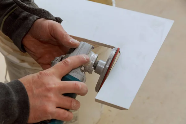 Worker cutting flooring tile with an diamond electric saw blade a construction site Royalty Free Stock Images