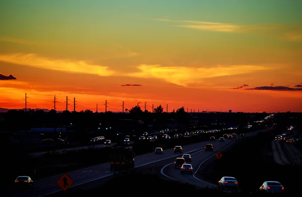 Landstraße mit bewölktem Himmel im Licht des Sonnenuntergangs — Stockfoto