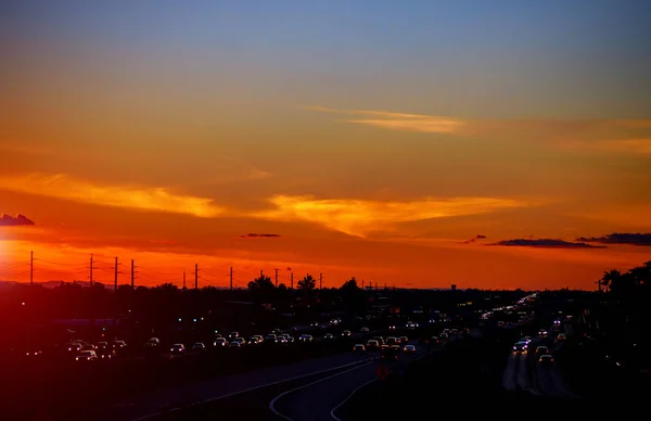 Snelweg verkeer bij zonsondergang verkeer in de VS. — Stockfoto