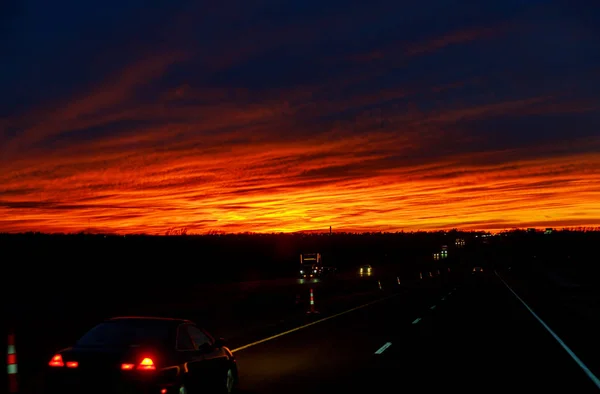 Carro ilumina a estrada neste pôr do sol paisagem crepúsculo cênica — Fotografia de Stock