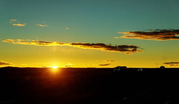 Transporte de caminhão ao pôr do sol dirigindo na estrada de asfalto — Fotografia de Stock