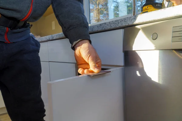 Instalación de tiradores de puerta en armarios de cocina con destornillador — Foto de Stock