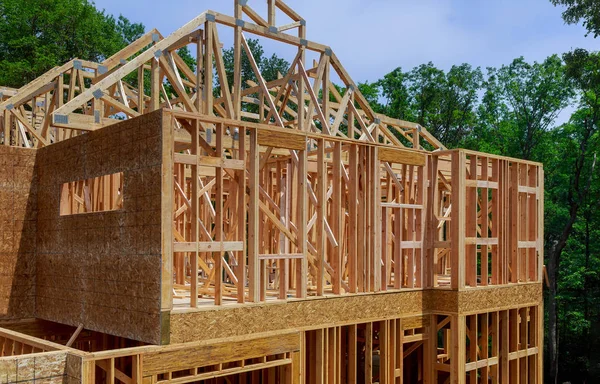 Açık mavi gökyüzünün altında güneş ışığıyla yeni inşaat kirişlerine bakıyorum.