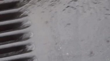 Yağmur suyu yolda akar ve delikler drenaj ile düşmek.