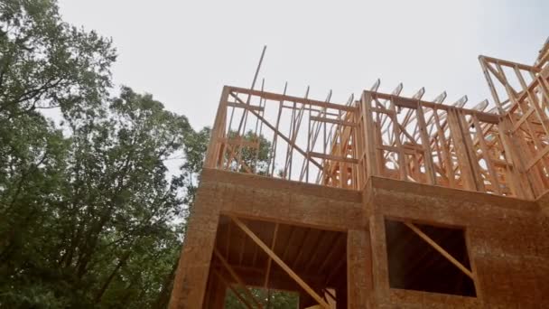 Looking up new construction beams under a clear blue sky with sunlight — Stock Video