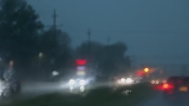 Moto offuscata sotto la pioggia con messa a fuoco selettiva strada notturna offuscata, al buio mentre forti piogge si riflettono sulla strada — Video Stock