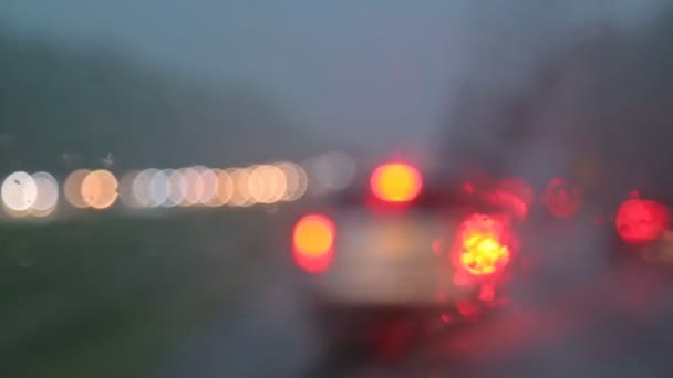 O tráfego pesado na chuva cai à noite com carros embaçados — Vídeo de Stock