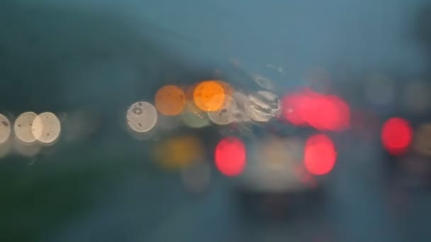 Colorful bokeh with street light at night rain falling on car traffic in the road — Stock Video