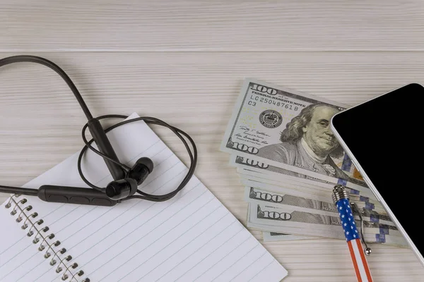 Fones de ouvido dólares americanos caneta smartphone e papel para o seu texto — Fotografia de Stock