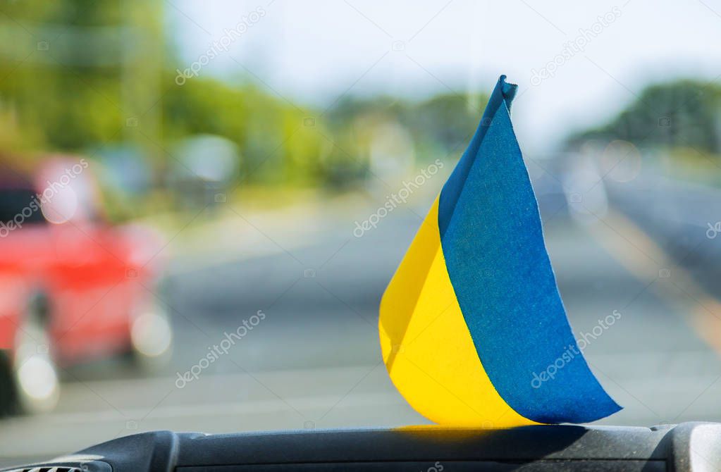 National symbol. Blue-yellow flag of Ukraine. Patriotic sign on glass inside the car.