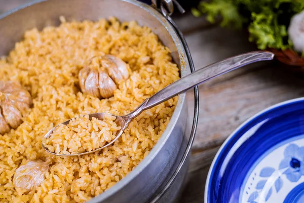 Özbek pilavı, demir tencere ve tabakta sarımsaklı pirinç. — Stok fotoğraf
