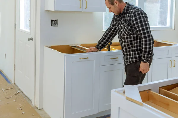 En snickare bygger ett lådor soptunna i köket — Stockfoto