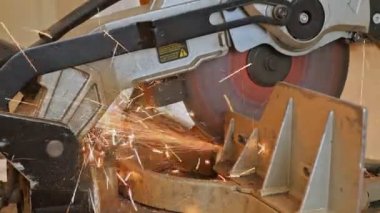 Öğütücüyle metal kesen bir işçi. Demir öğütürken kıvılcımlar