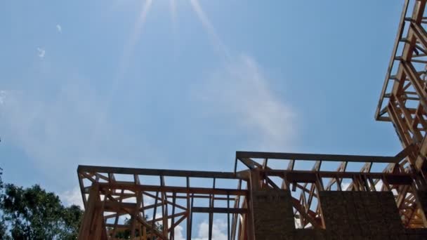 Looking up new construction beams under a clear blue sky with sunlight — Stock Video