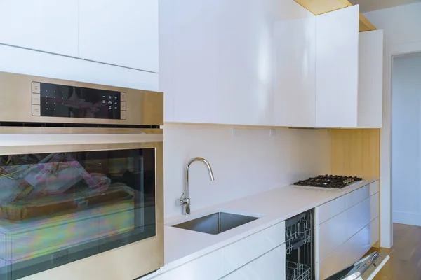 Interior da cozinha moderna com eletrodomésticos na parte superior do fogão, balcão de mármore com armários brancos de cozinha — Fotografia de Stock