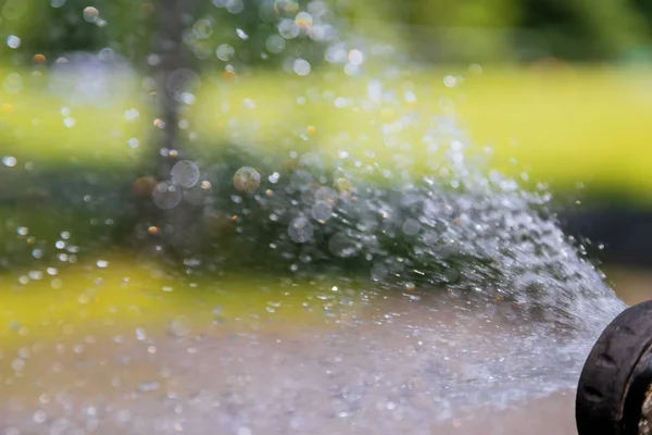 Arrosage du jardin dans un tuyau un ruisseau d'eau propre — Photo