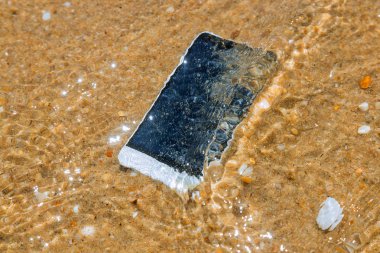 Kumlu bir plajda hava ile akıllı telefon
