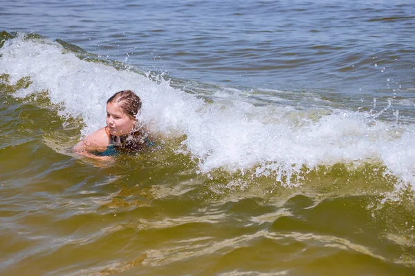 Menina nadando em um anel de borracha no mar. Uma criança nada com tempo de verão ensolarado — Fotografia de Stock