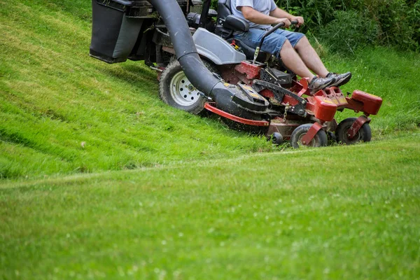 Pemotong rumput di halaman merah. Proses berkebun dari memotong rumput — Stok Foto