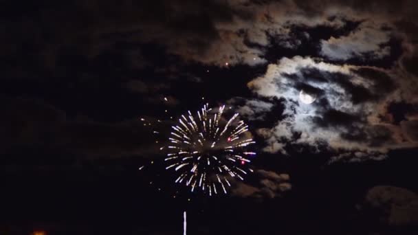 La pleine lune dans une nuit nuageuse obscurcit la lune dans des feux d'artifice colorés au-dessus du ciel nocturne — Video