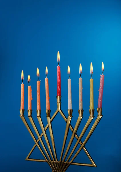 Brennende Chanukka-Kerzen in einer Menora auf blauem Hintergrund — Stockfoto