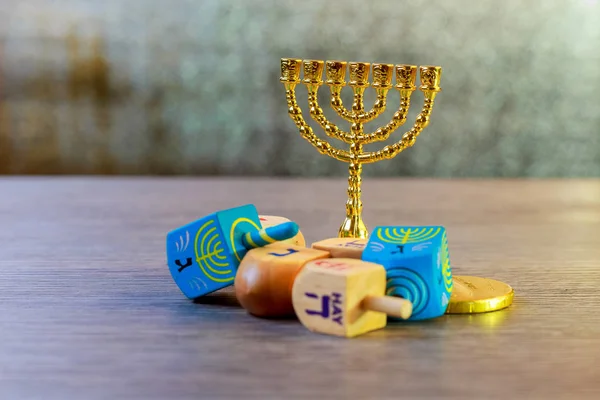 jewish holiday Hanukkah with wooden dreidels colection spinning top and chocolate coins on the table