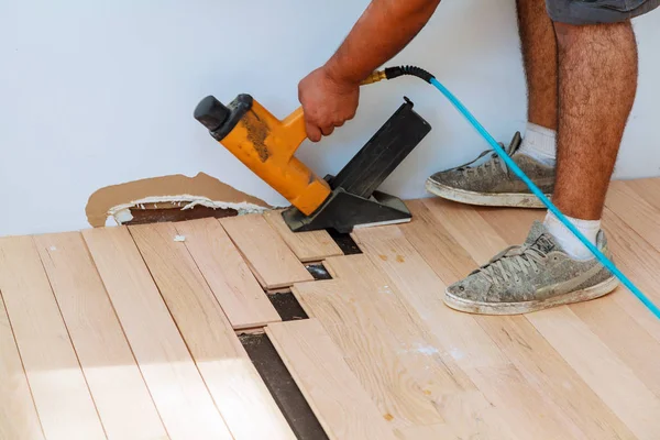 Falegname che installa parquet in legno con martello — Foto Stock