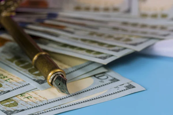 Dólares cem notas em dinheiro com uma caneta — Fotografia de Stock