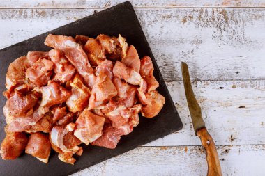 Bıçaklı siyah tahta üzerinde kesilmiş et parçaları