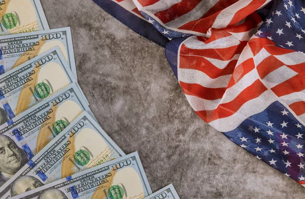 Экономические 100 долларов США завернуты в американский флаг — стоковое фото