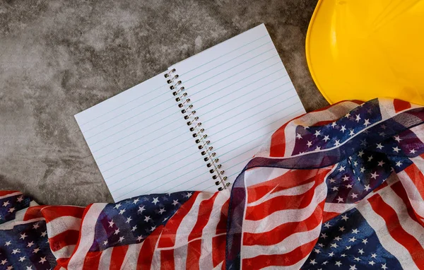 Labor day concept yellow helmet on USA national flag