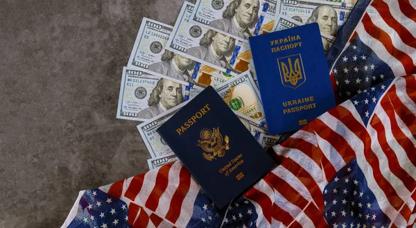 Ukrainian passport and American Passport in the US flag with bills of one hundred dollars