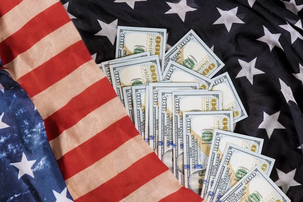Банкноты в долларах США на фоне флага США — стоковое фото