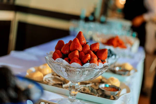 Rote, reife Erdbeeren in einer Glasschale auf weißem Tisch — Stockfoto
