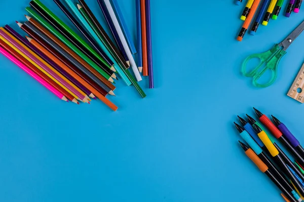 Tanszerek, színes ceruza felső határ a kék háttér — Stock Fotó
