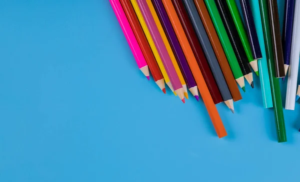 Цветные карандаши на голубом фоне, школьные принадлежности — стоковое фото