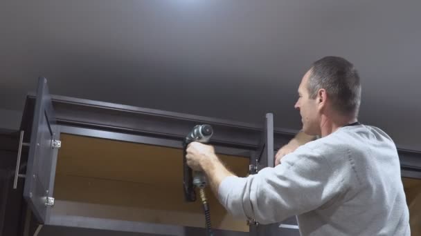 Cozinha carpinteiro instalação de moldar coroa guarnição moldura no armário — Vídeo de Stock