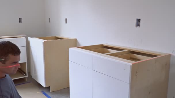 Worker installs drawer to kitchen cabinet construction kitchen — Stock Video