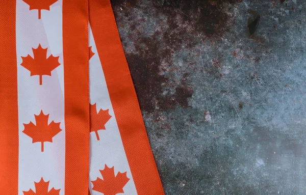 Kanadische rot-weiße Flagge vor dunklem, rustikalem Hintergrund für Kanada-Feierlichkeiten und Nationalfeiertage — Stockfoto